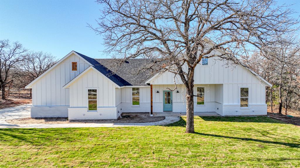 a front view of house with yard and trees around