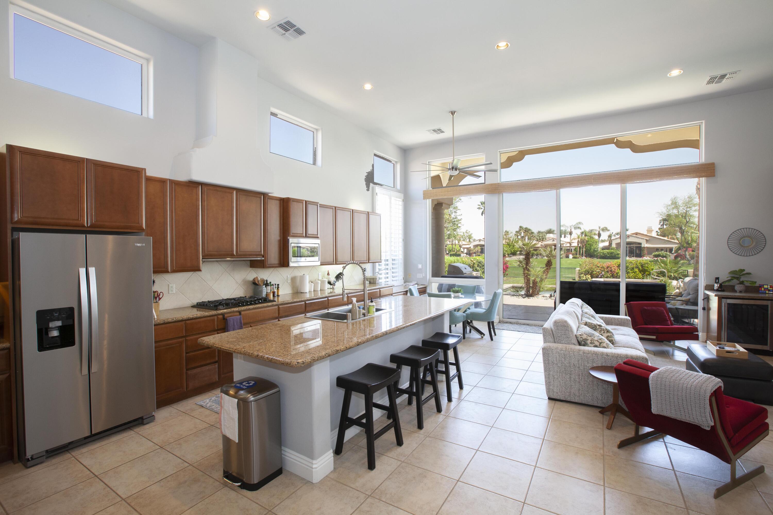 a kitchen with granite countertop a table chairs stove and refrigerator