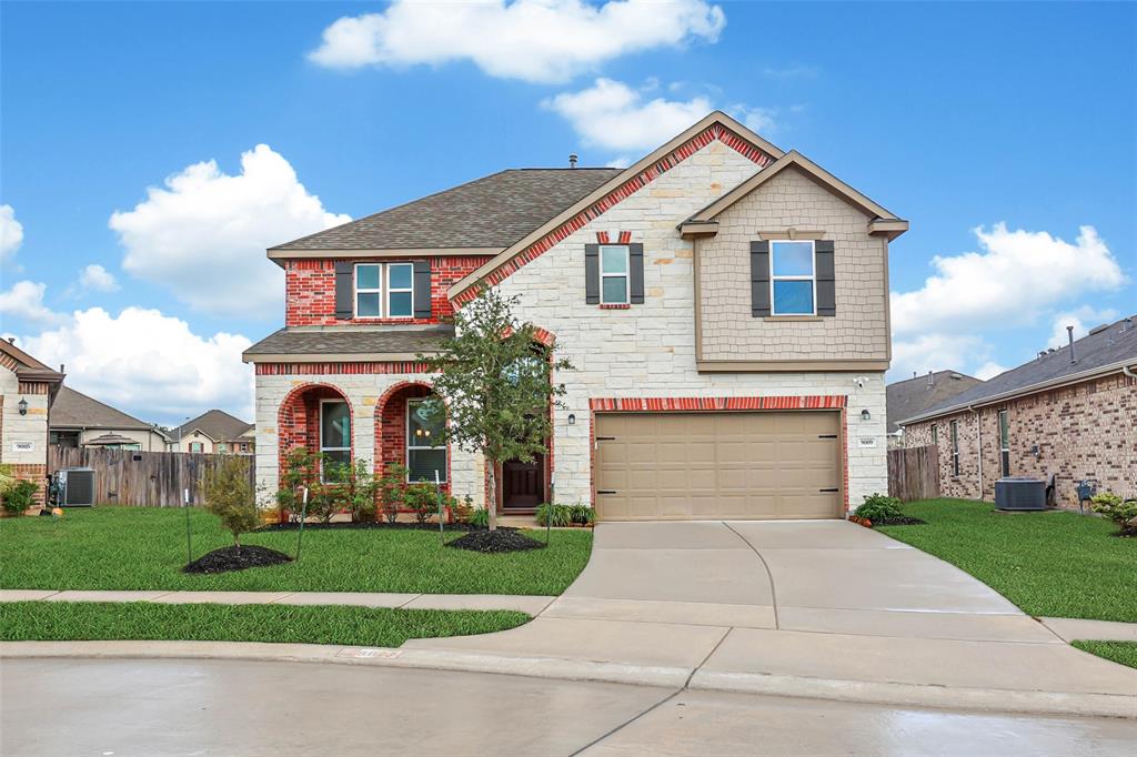 a front view of a house with a yard and garage