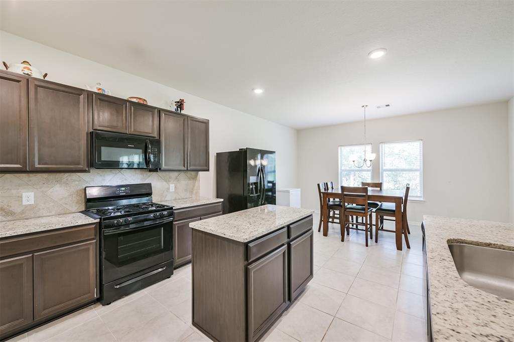 a kitchen with a refrigerator and a stove top oven