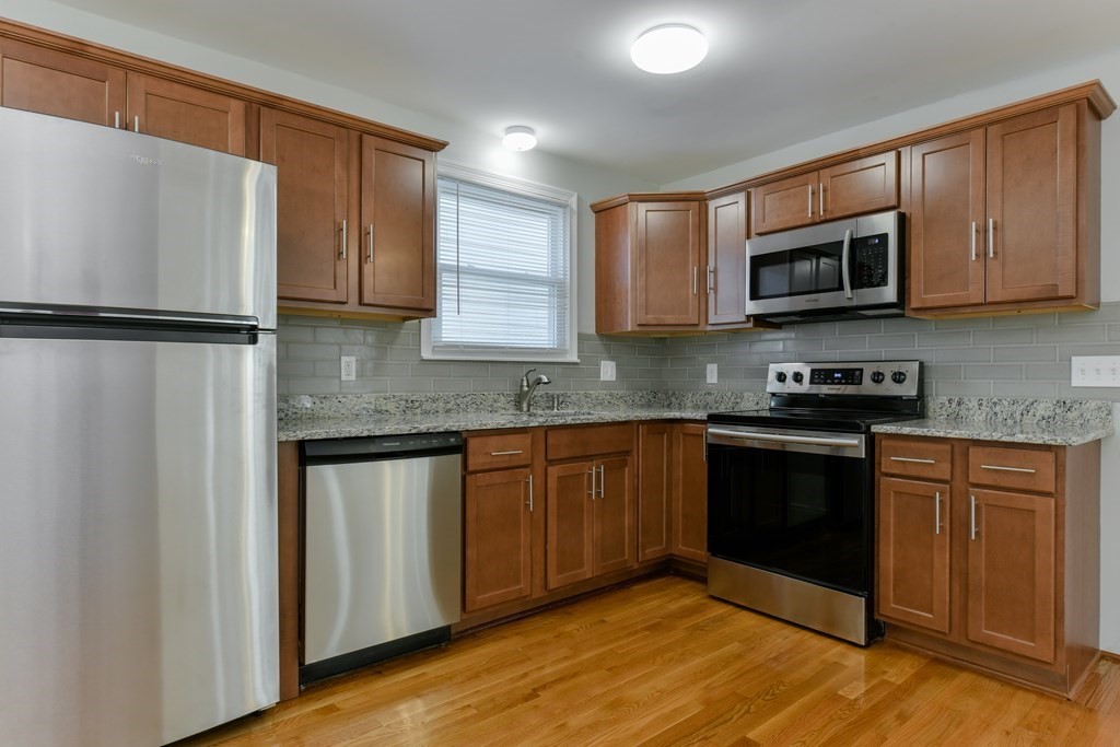 a kitchen with stainless steel appliances granite countertop a refrigerator sink and microwave