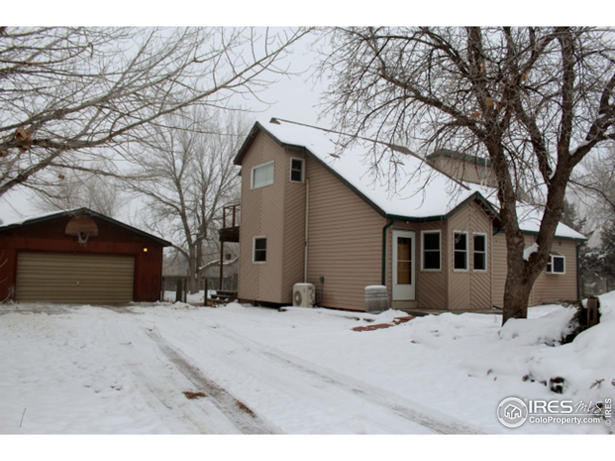 a front view of a house with a yard covered in snow