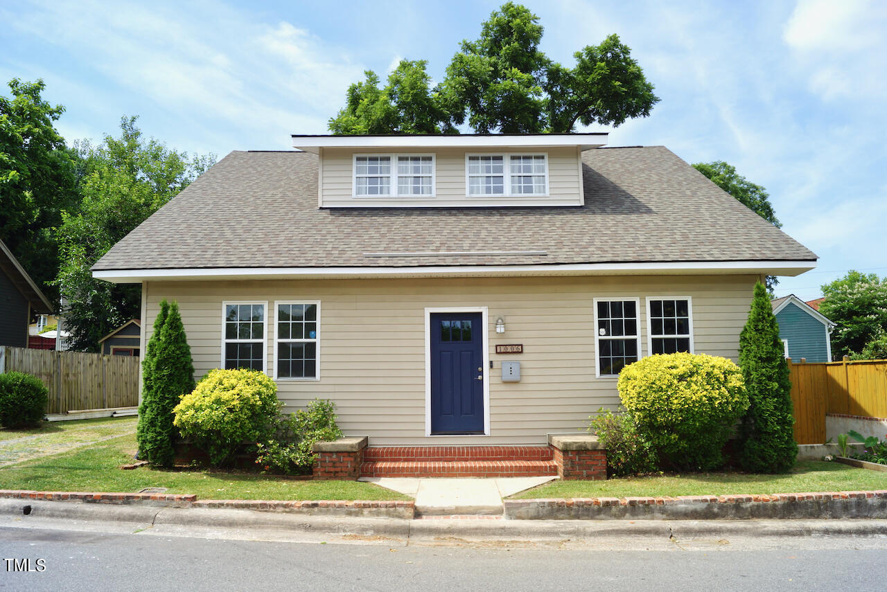 a front view of a house with a garden and garage