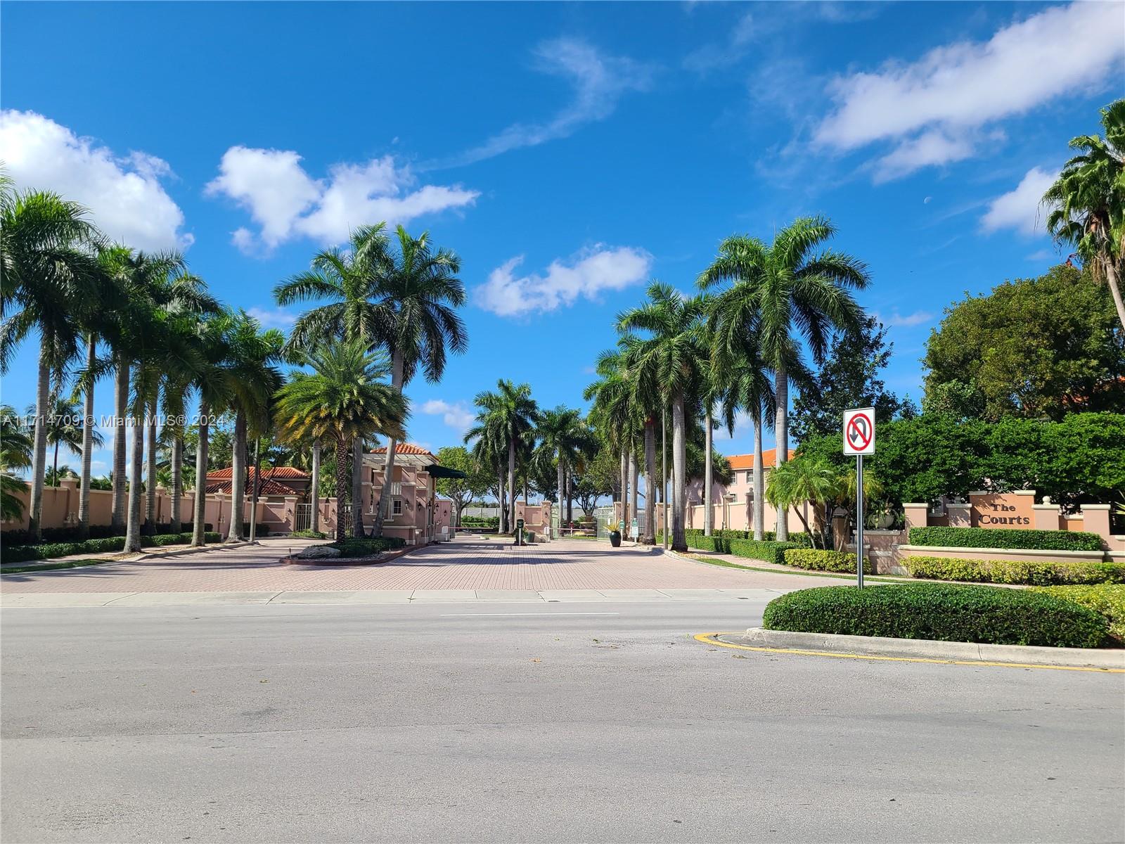 front view of a house with a yard and palm trees