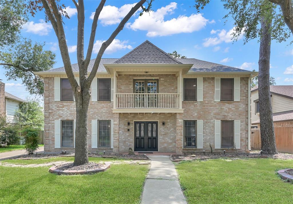 front view of a brick house with a yard