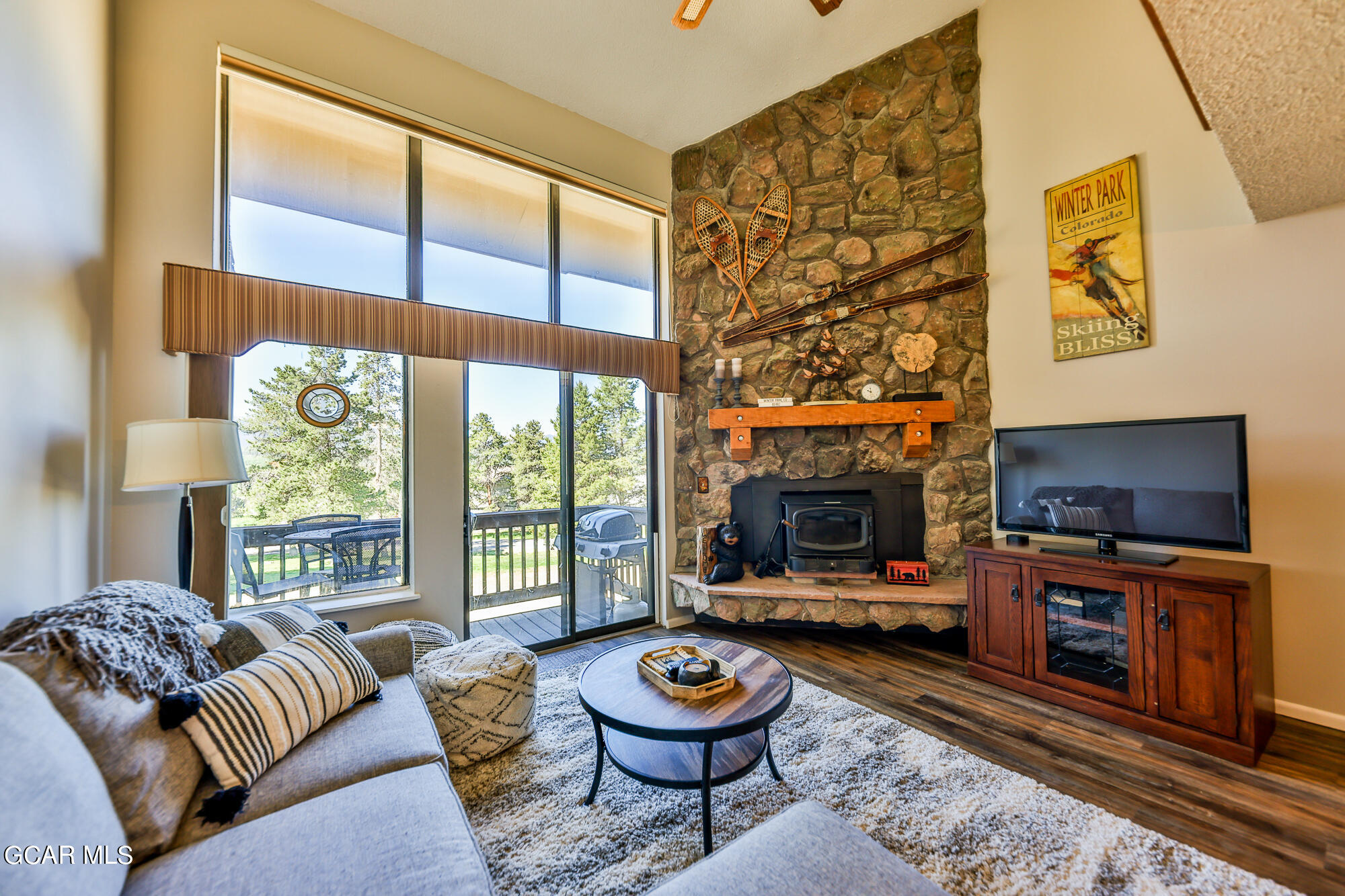 a living room with furniture a flat screen tv and a fireplace