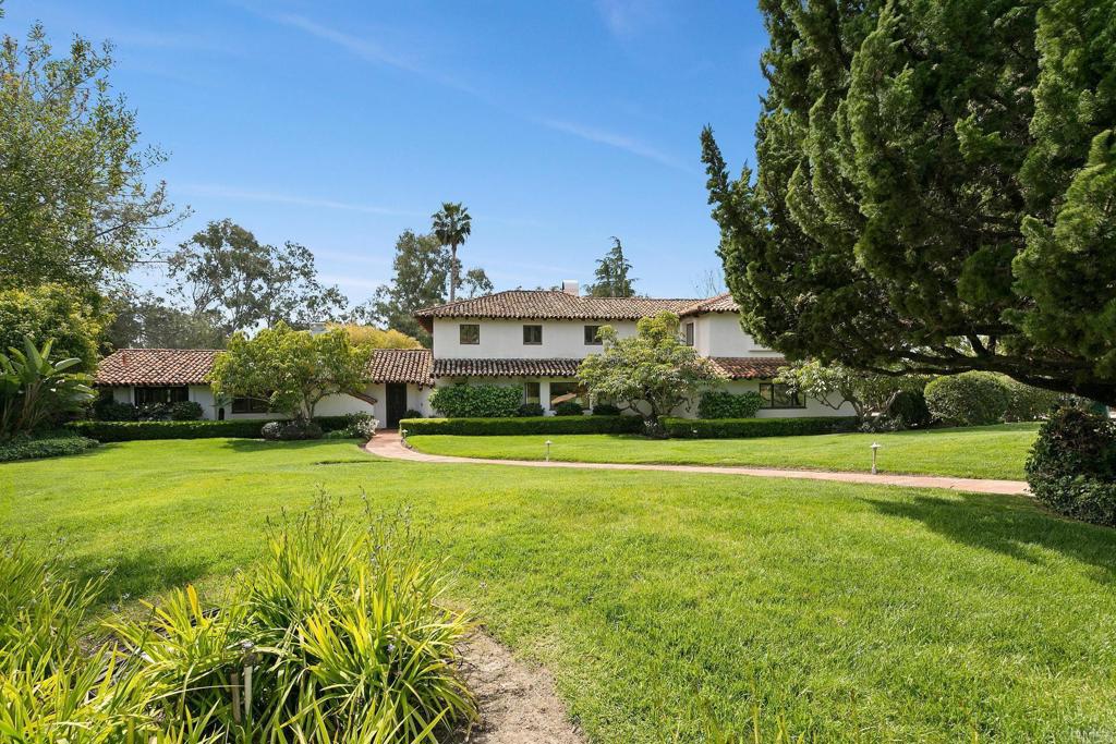 a front view of a house with a yard and trees