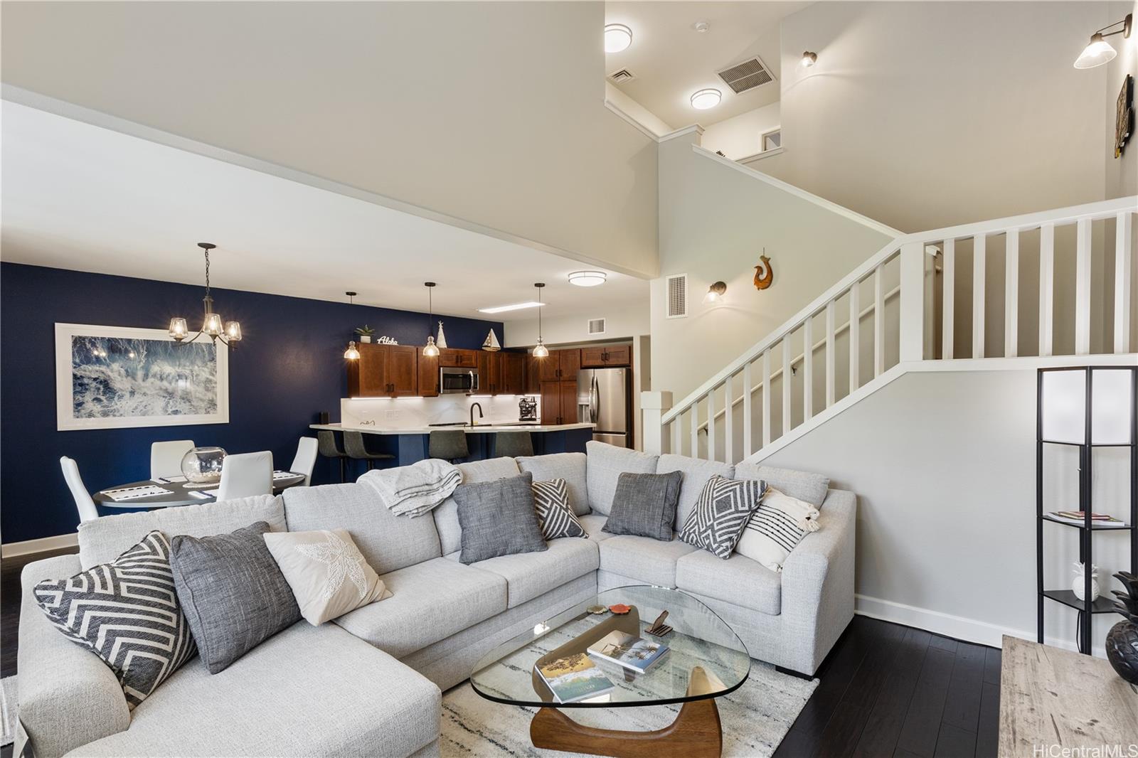 a living room with furniture kitchen view and a chandelier