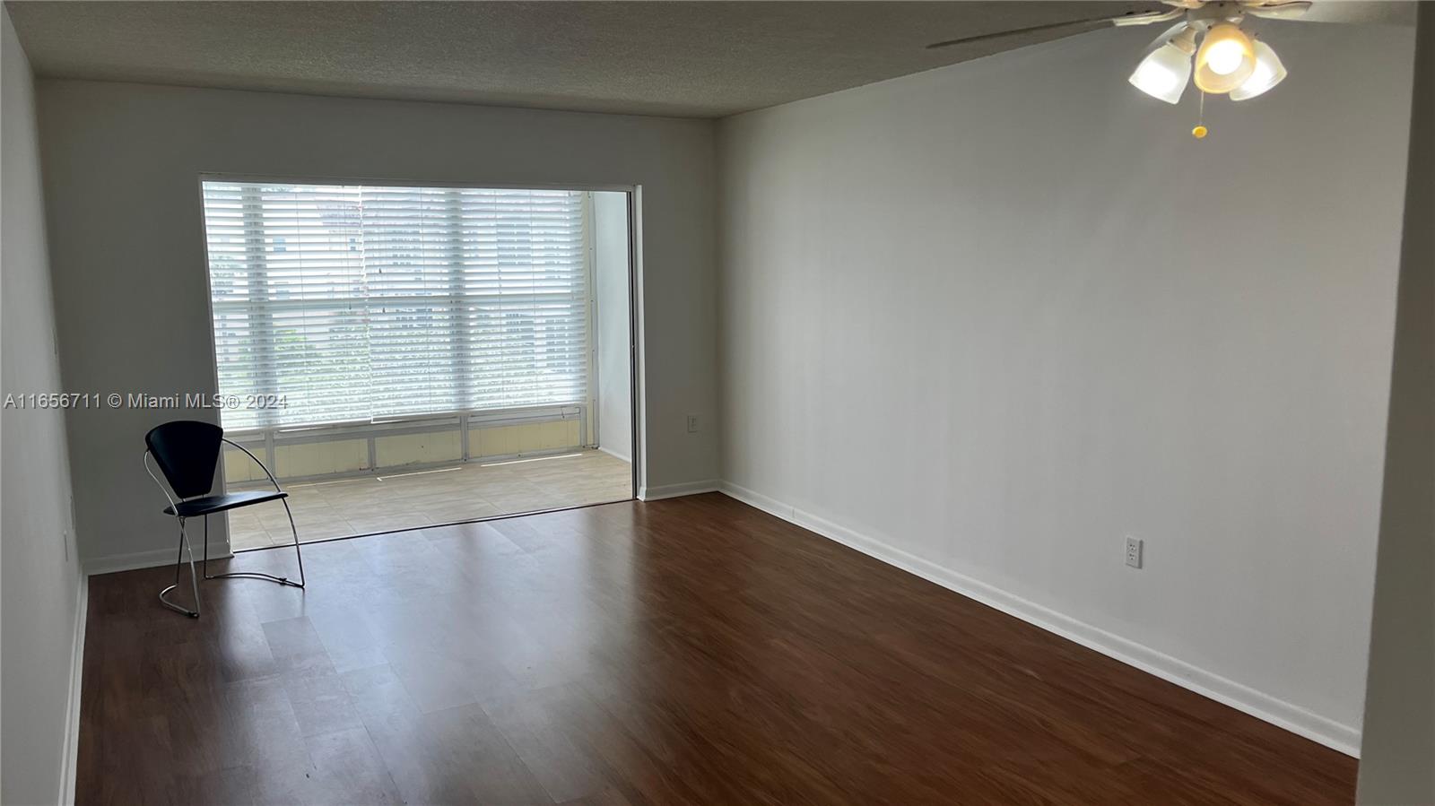 a view of a livingroom with wooden floor and a window