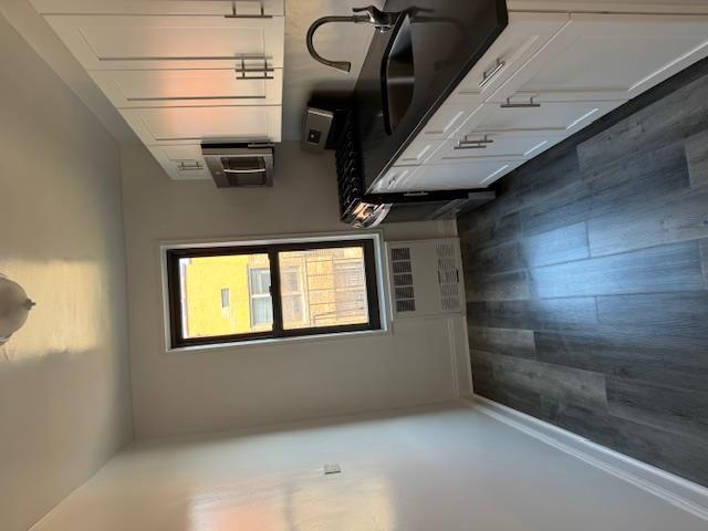 a kitchen with granite countertop a sink a stove and cabinets