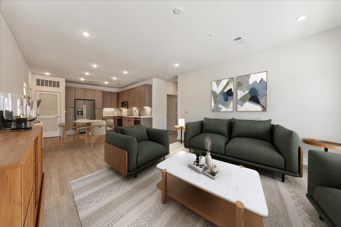 a living room with furniture and a view of kitchen