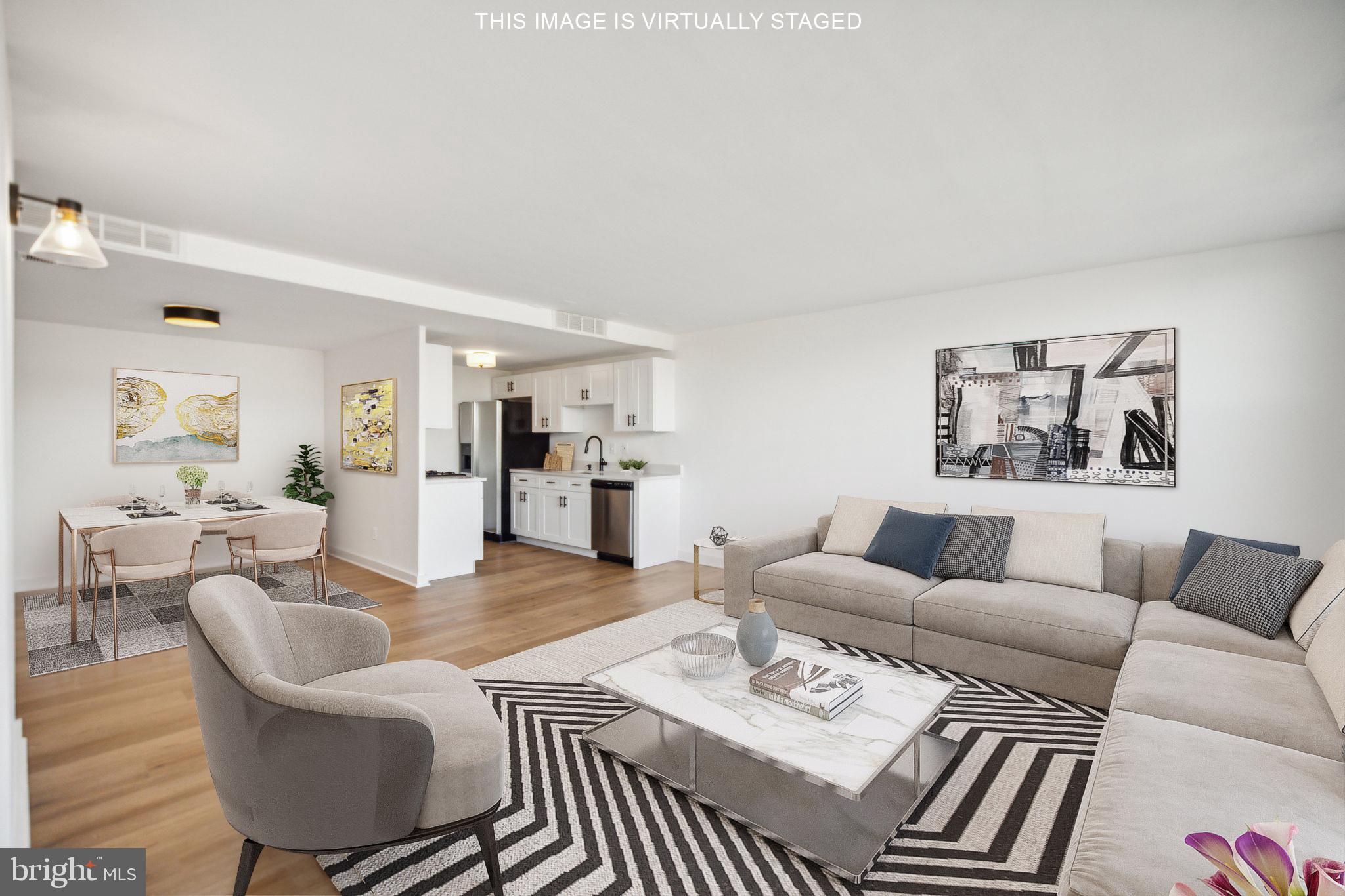 a living room with furniture a table and kitchen view