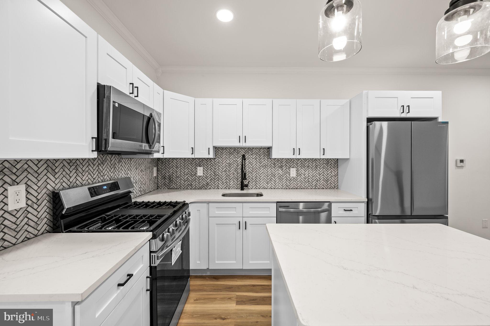 a kitchen with stainless steel appliances a stove a sink a refrigerator and cabinets