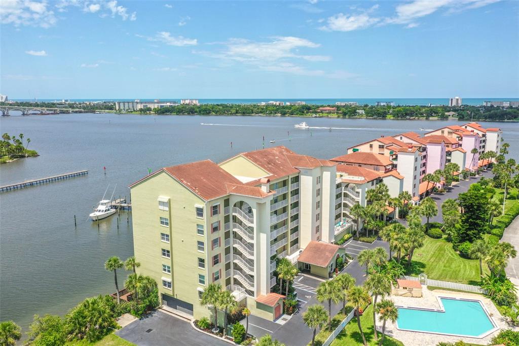 an aerial view of residential houses with outdoor space and ocean view