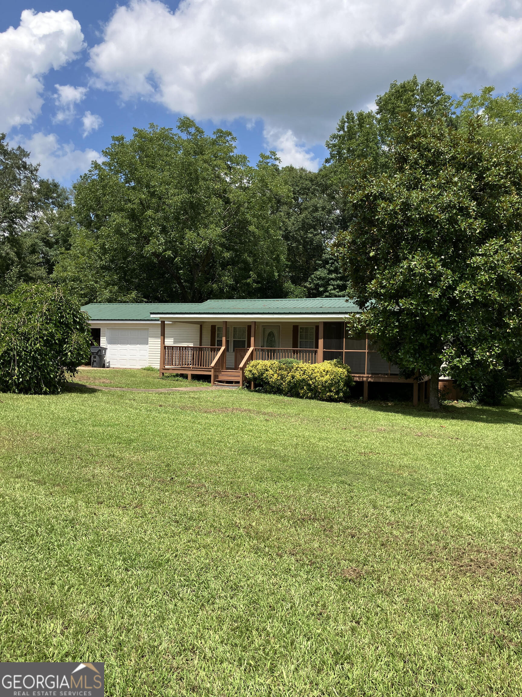 a front view of a house with a yard and trees