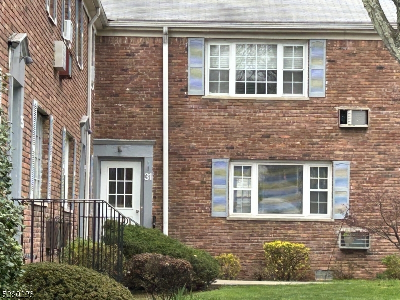 a view of a brick house with large windows