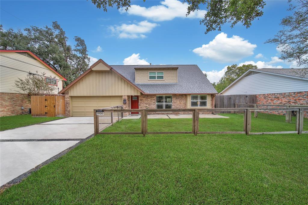 a view of house with a big yard and large trees