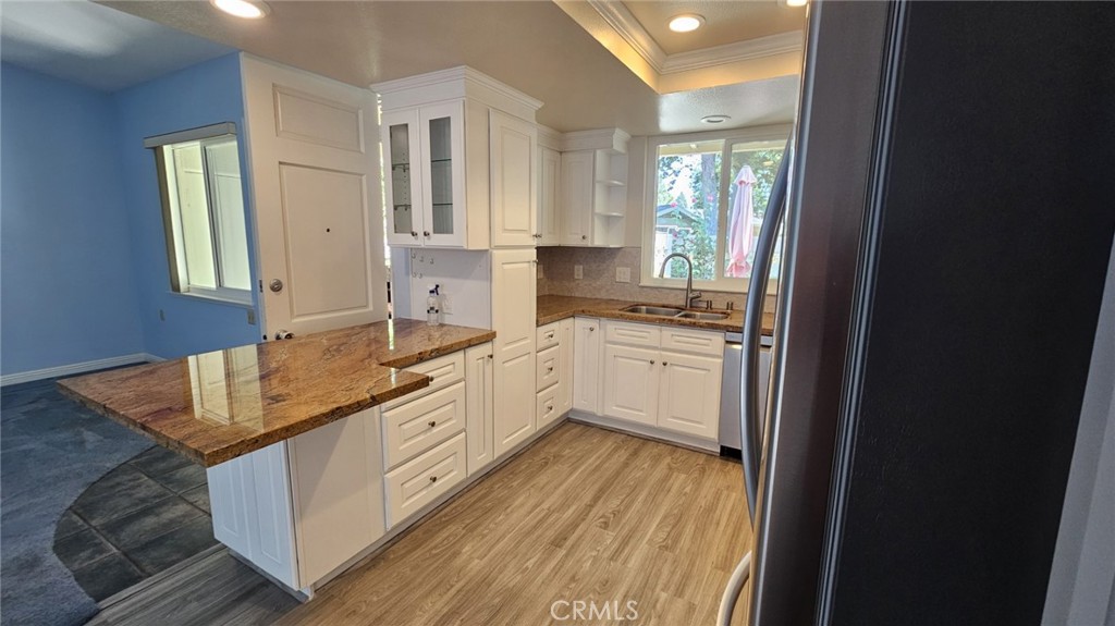 a kitchen with granite countertop a sink stove and cabinets