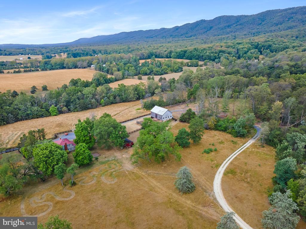 an aerial view of a house with a garden and lake view