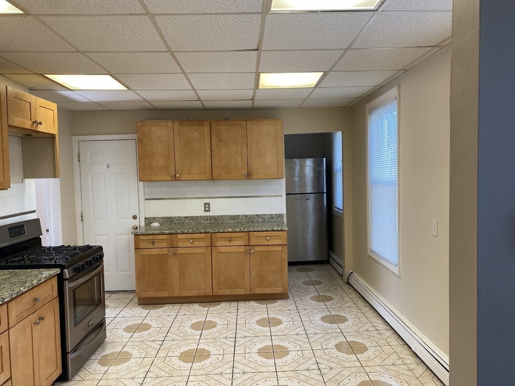 a kitchen with stainless steel appliances granite countertop a refrigerator and a stove top oven