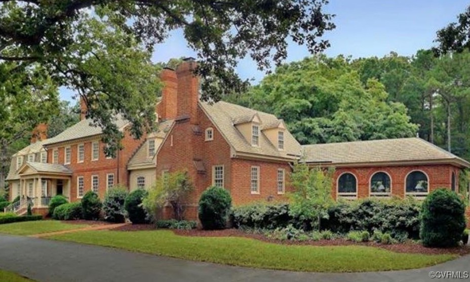 a aerial view of a house with yard and trees