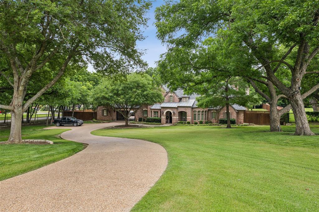 a view of a house with a big yard and palm trees