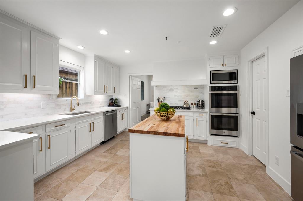 a kitchen with stainless steel appliances kitchen island granite countertop a stove and a sink