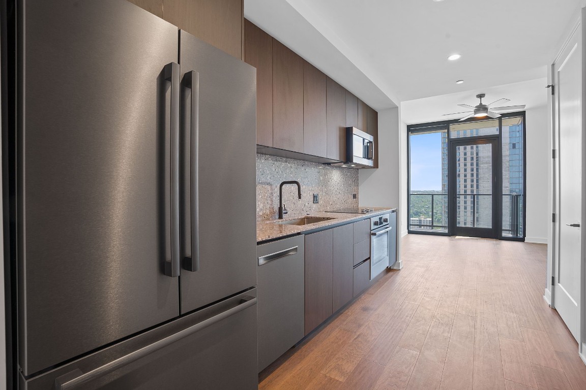 a large kitchen with a sink and refrigerator