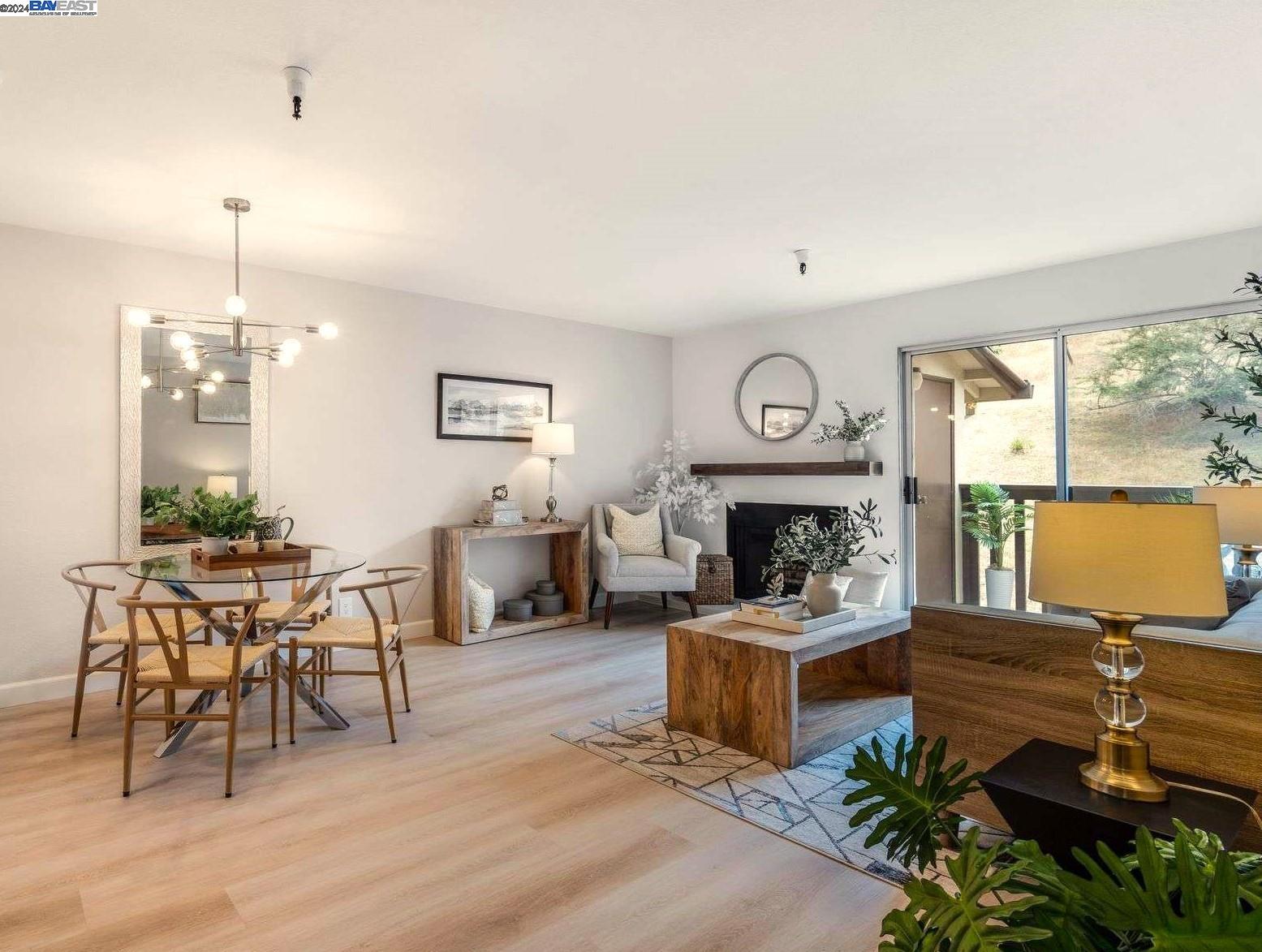 a living room with furniture a fireplace and a floor to ceiling window