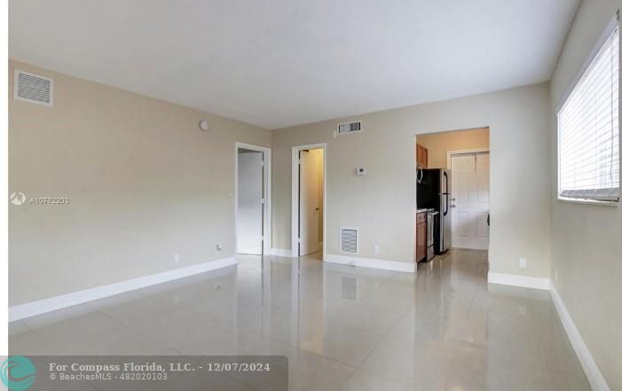 a view of empty room with wooden floor and window