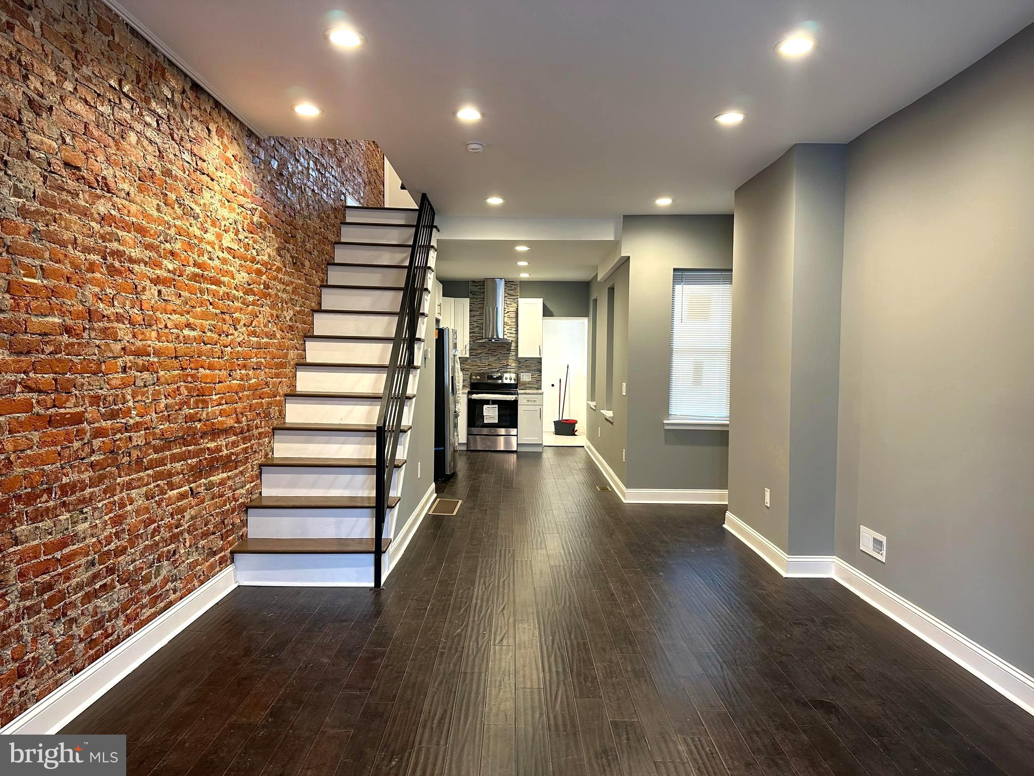 a view of a room with wooden floors and stairs