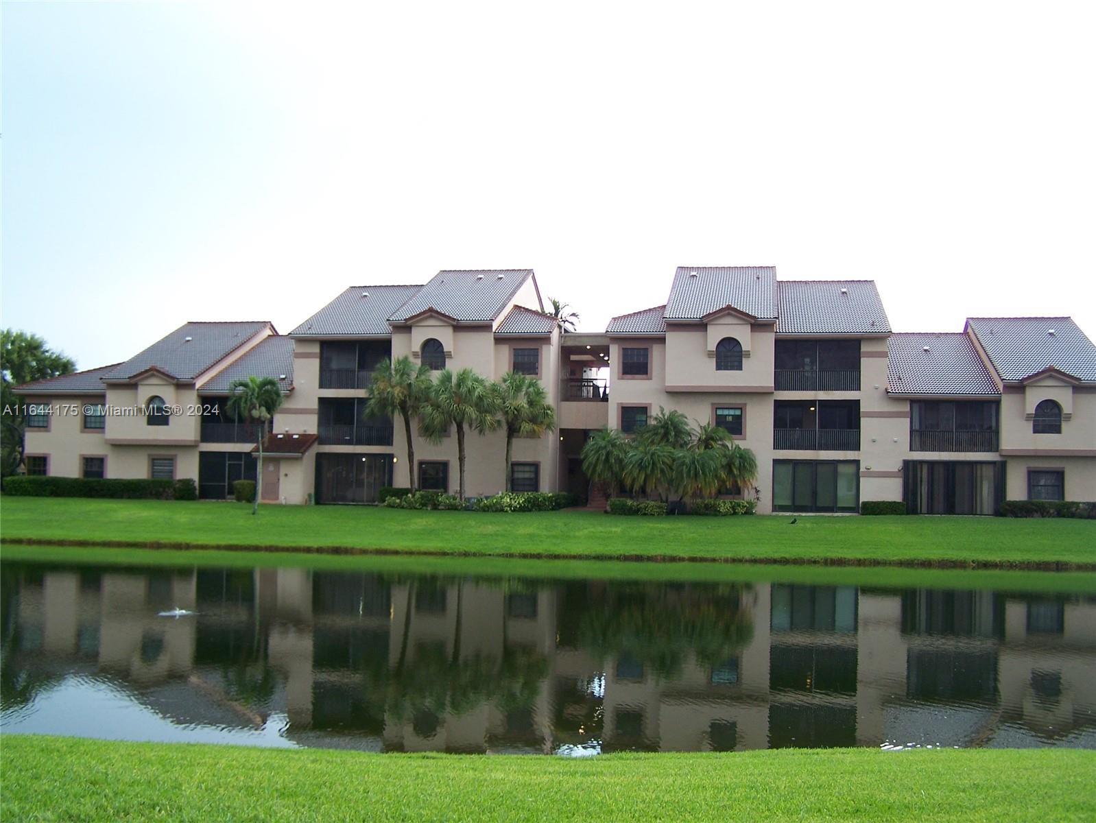 a front view of a house with a yard and green space