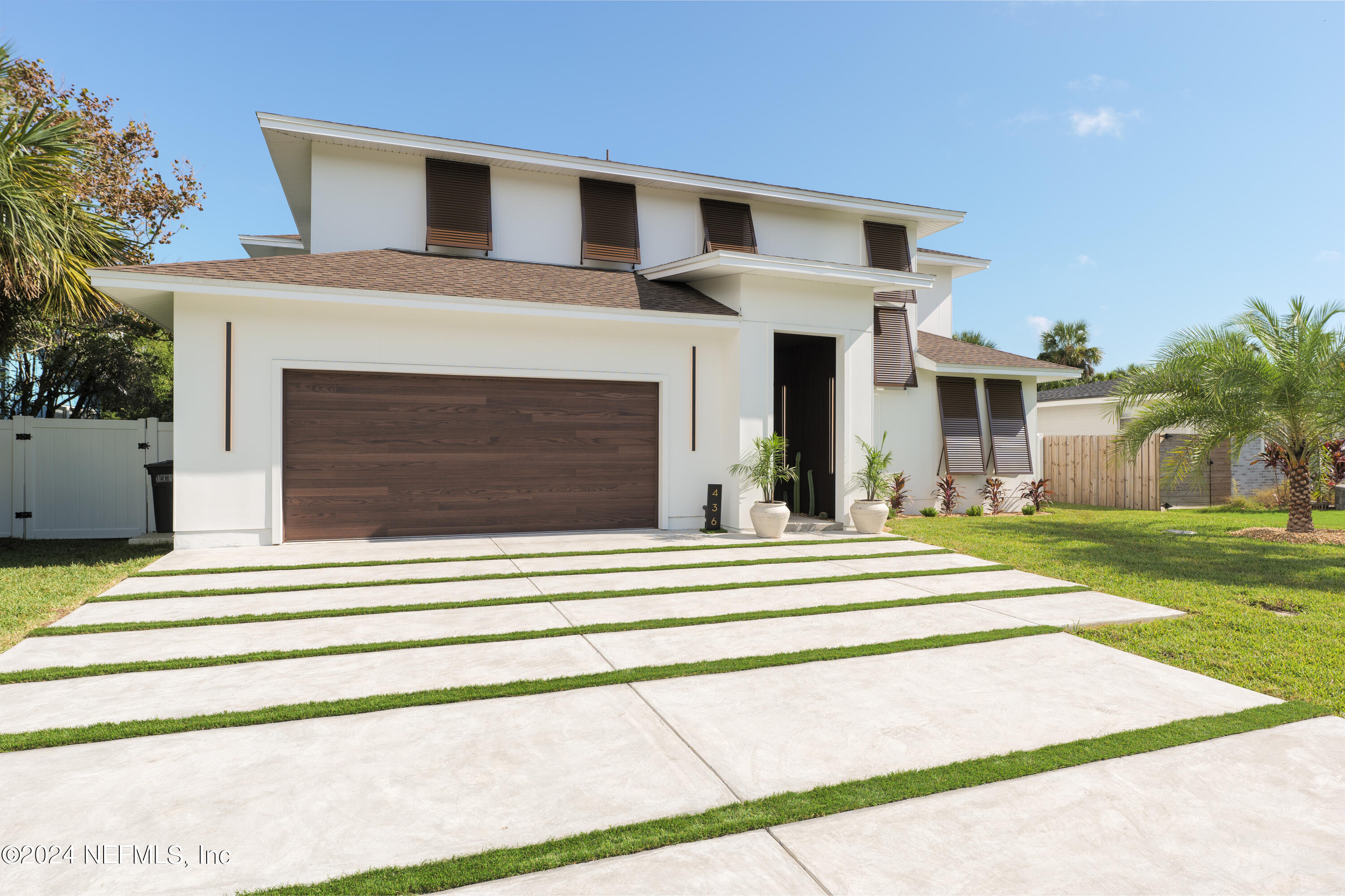 a front view of a house with a garden and garage