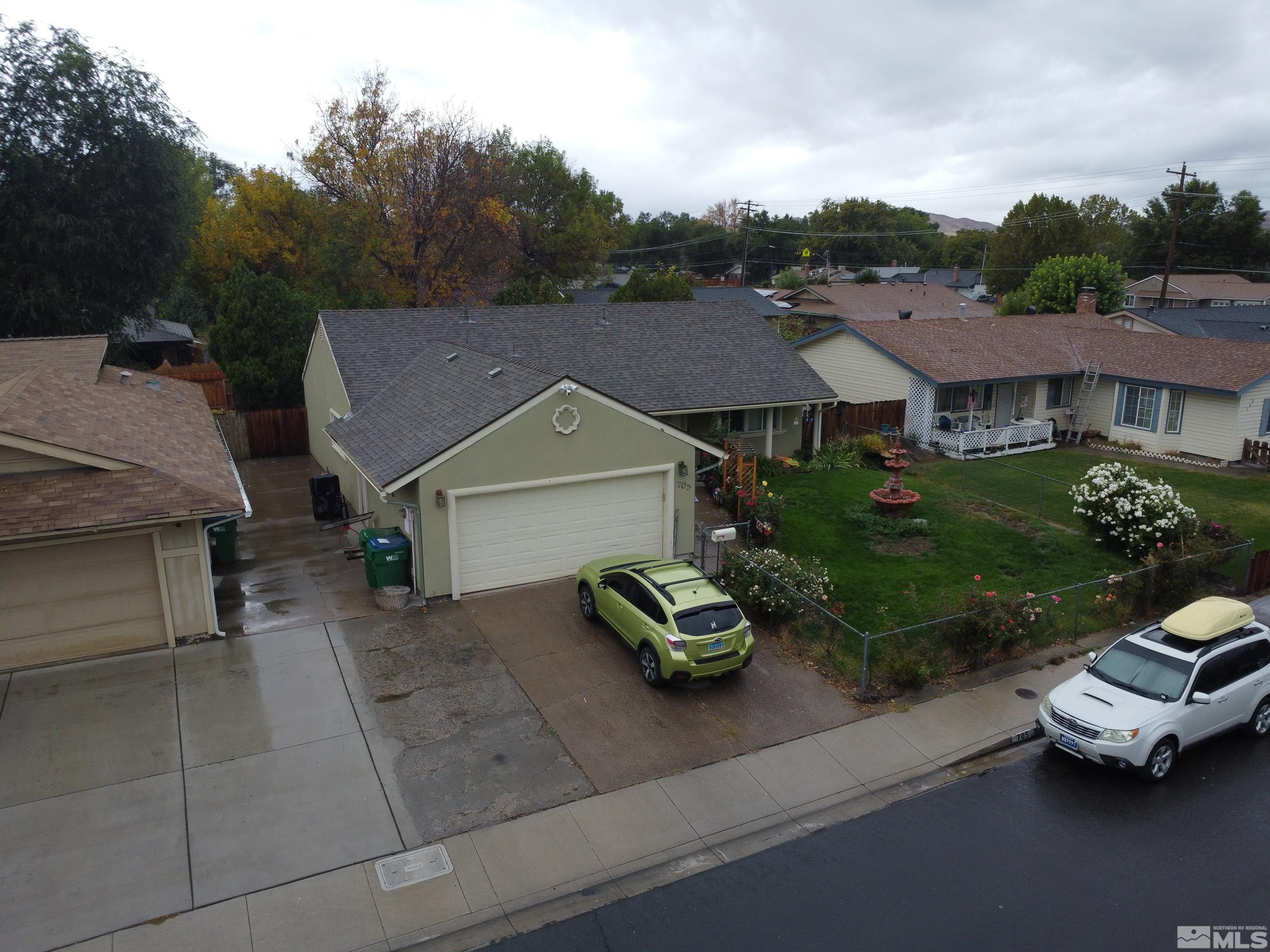 an aerial view of a house with garden space and car parked