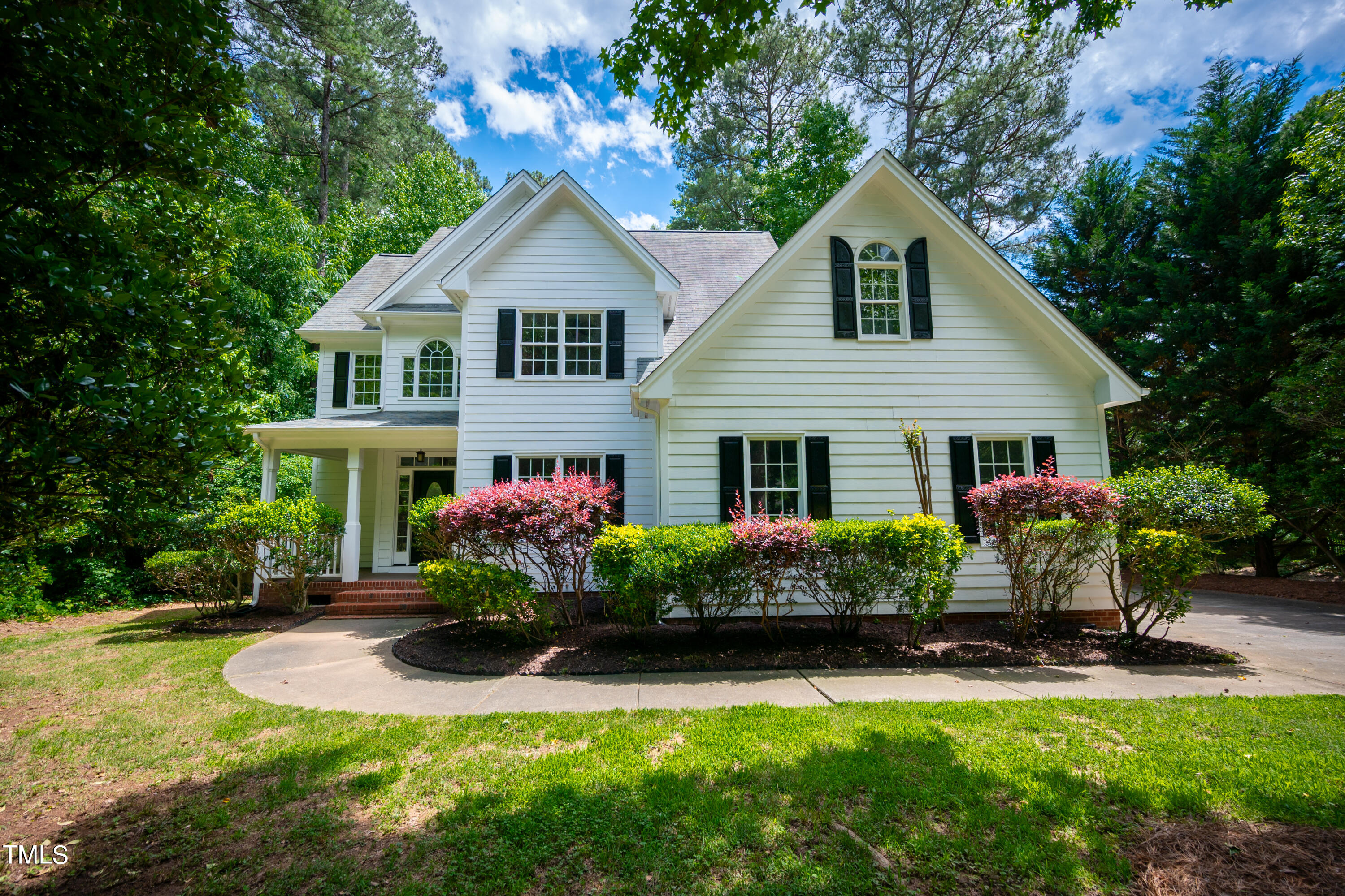 a front view of a house with a yard and potted plants