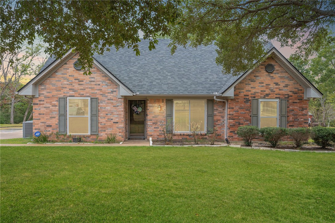 a front view of a house with a garden and yard