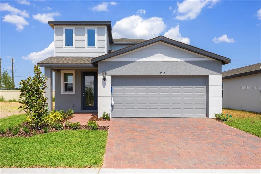 a front view of a house with a yard and garage