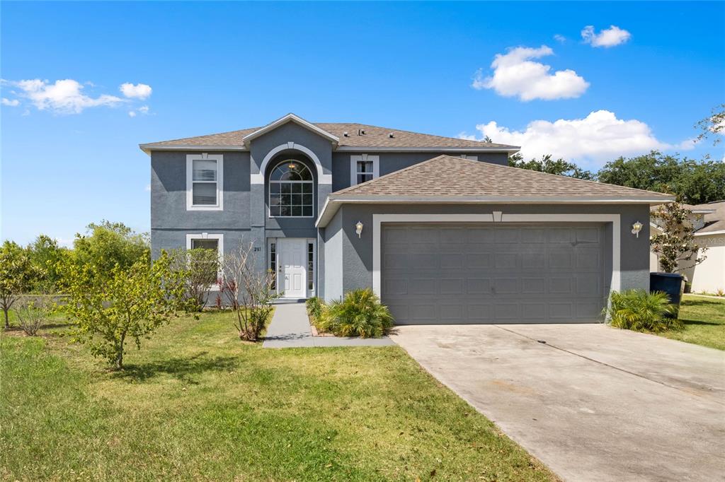 a front view of a house with a yard and garage