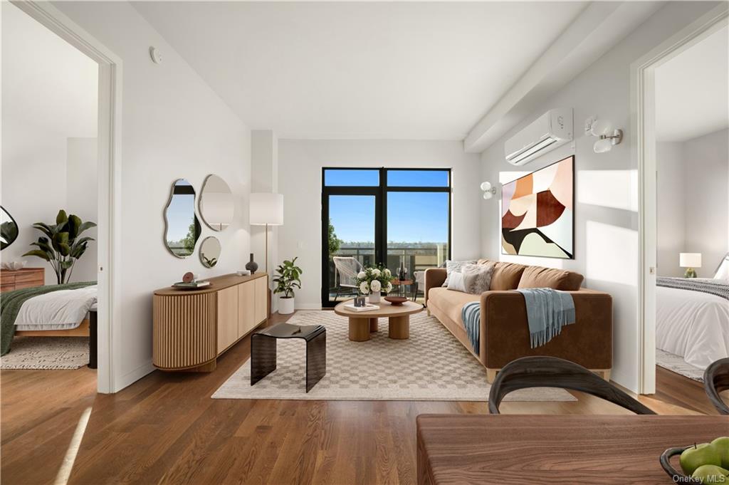 a living room with furniture large window and wooden floor