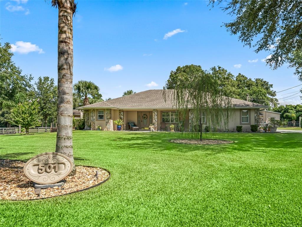 a front view of a house with a garden and trees