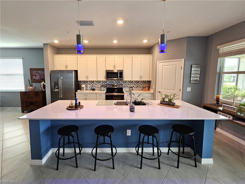 a dining room with stainless steel appliances a dining table and chairs