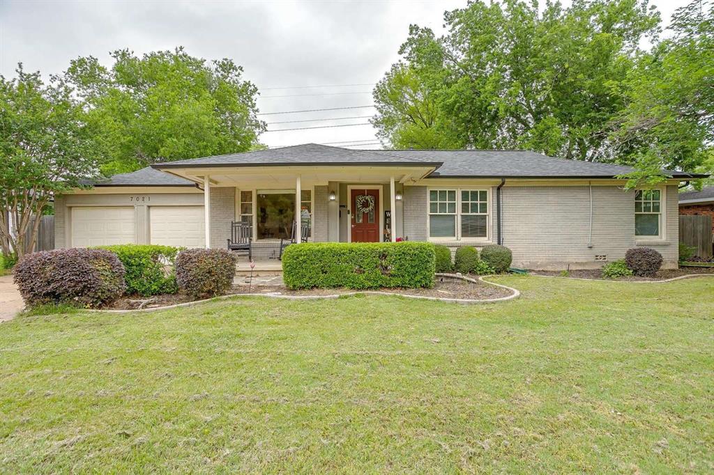 a view of a house with a patio and a yard