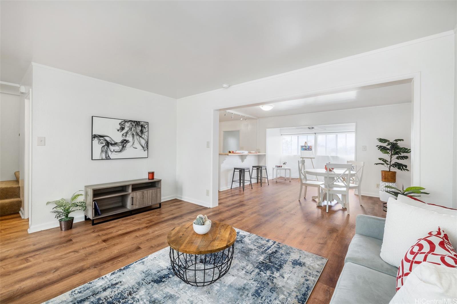 a living room with furniture and wooden floor