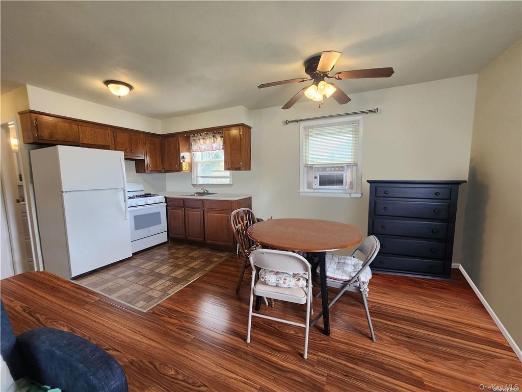 a kitchen with granite countertop wooden floors and white stainless steel appliances