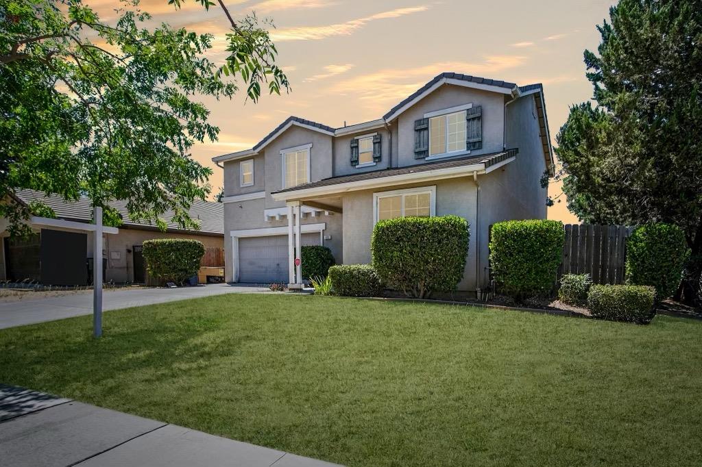 a front view of a house with a yard and garage