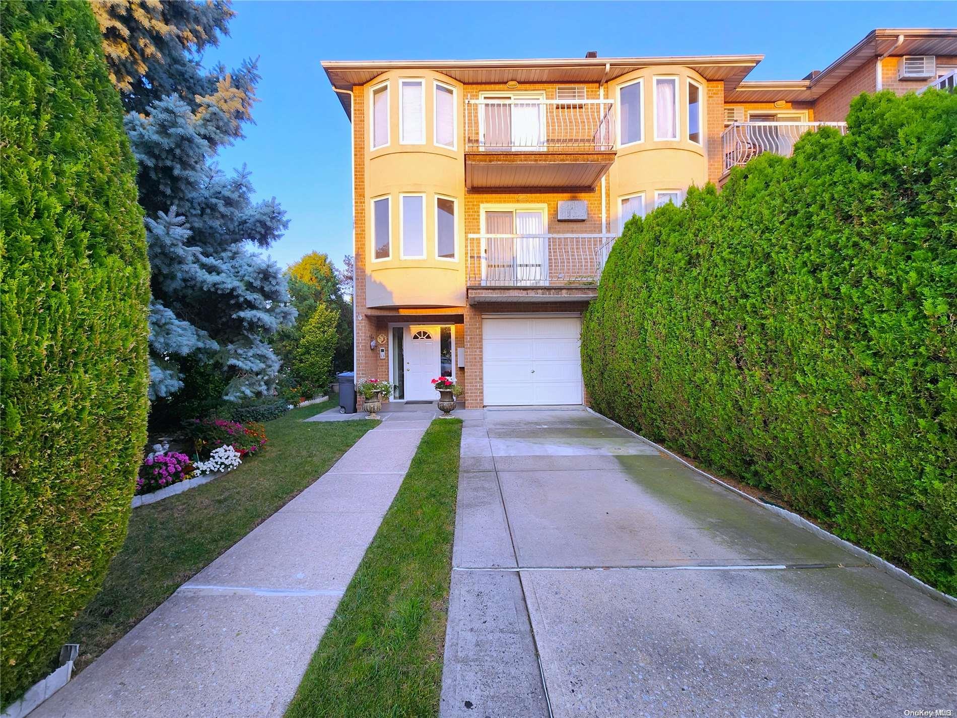 a front view of a house with a yard and trees