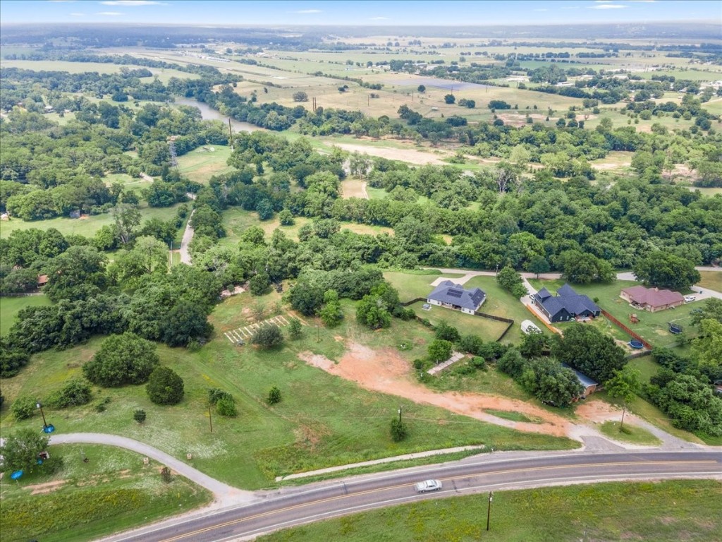 an aerial view of residential houses with outdoor space and trees