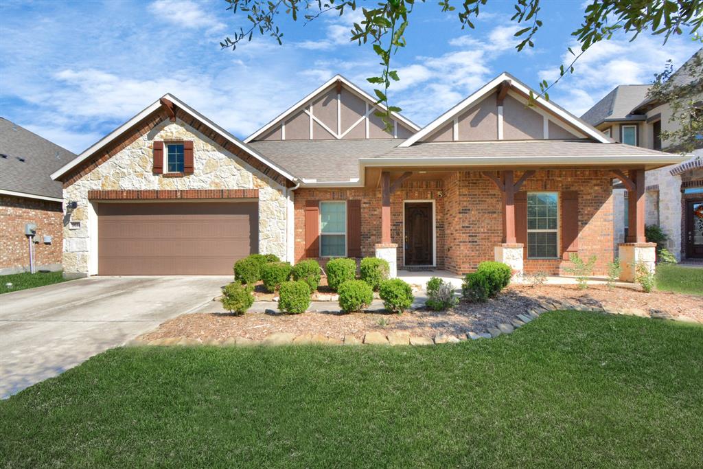 a front view of a house with a yard and potted plants