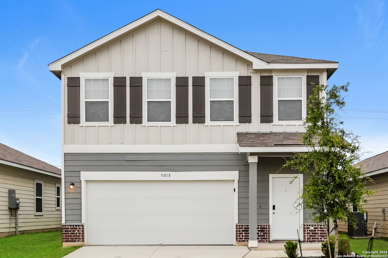 a front view of a house with a garden and garage