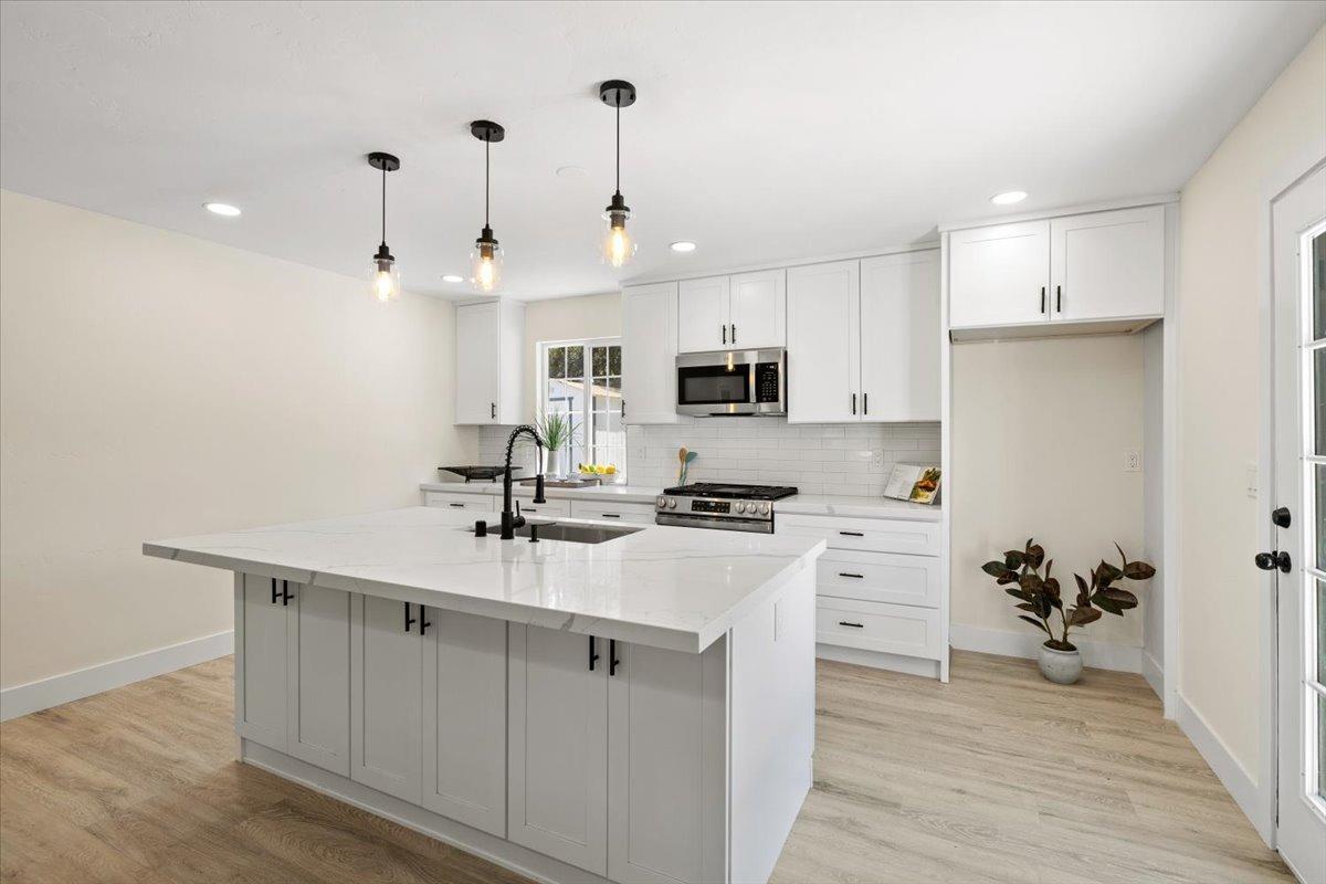 a kitchen with white cabinets and stainless steel appliances